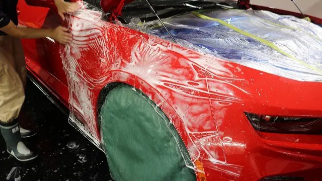 マスタングのフェンダーにプロテクションフィルムを貼る様子